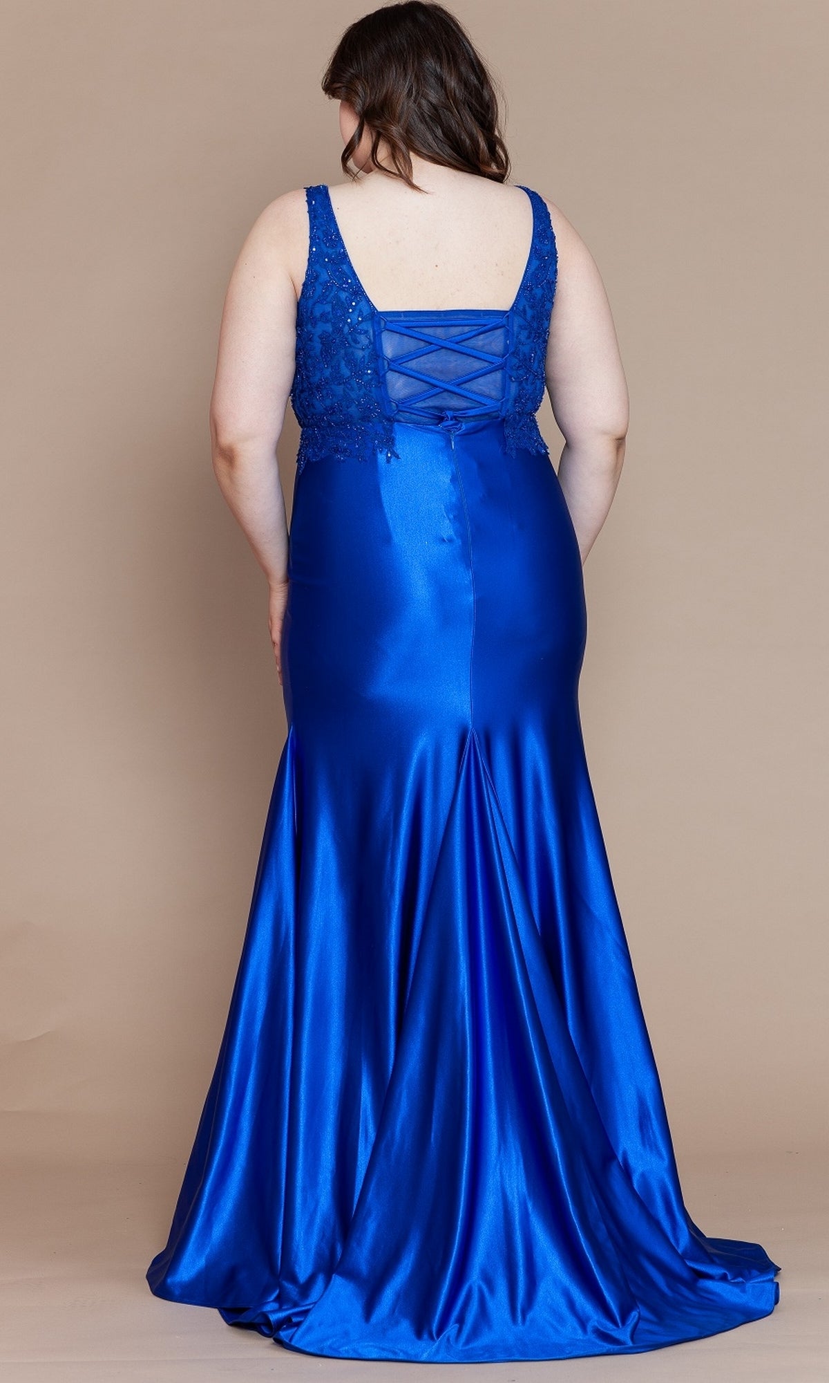 A woman showcases the Embroidered-Bodice Plus-Size Long Prom Dress W1160 in royal blue satin, featuring a lace-up back, as she stands facing away against a plain beige background.